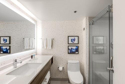a bathroom with a toilet and a sink and a shower at Crowne Plaza Suites Arlington, an IHG Hotel in Arlington