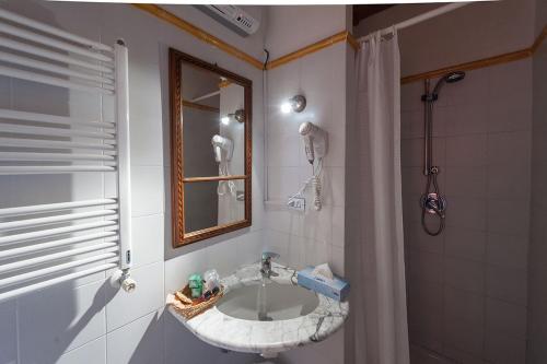 a bathroom with a sink and a mirror and a shower at Dimora del Prete di Belmonte in Venafro