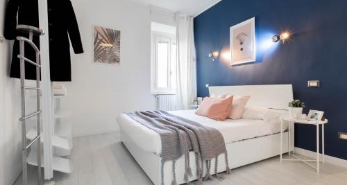 1 dormitorio con cama blanca y pared azul en JOIVY Vibrant Flat for 4 near parks, in Navigli, en Milán