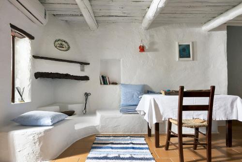 a room with a table and a chair and a couch at Koutsounari Traditional Cottages in Koutsounari