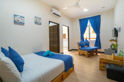 a bedroom with a king sized bed and a chair at Paretto Seaview Hotel in Pantai Cenang
