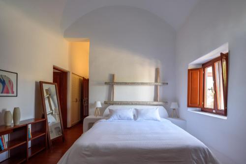 a bedroom with a white bed and two windows at Aquaria Villa in Karterados