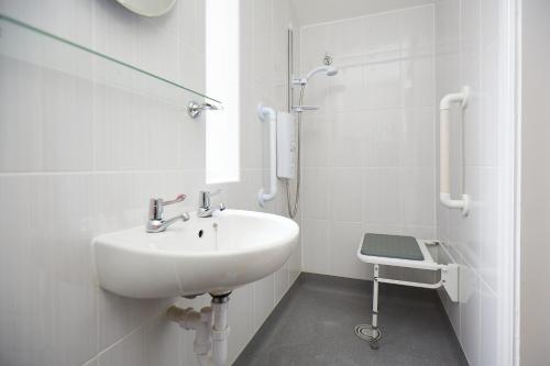 a white bathroom with a sink and a shower at The Nook in Huddersfield