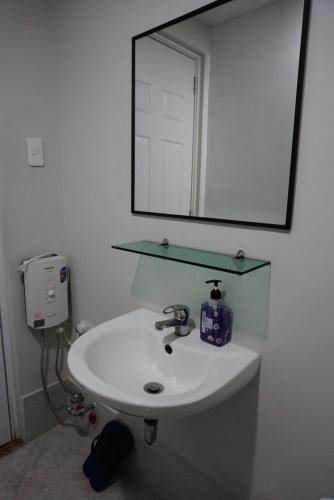 a bathroom with a sink and a mirror at Cozy condo unit 5mins from Mactan Cebu Int'l Airport with Netflix in Mactan
