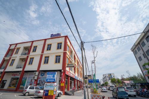 a building on a city street with cars parked at Paretto Seaview Hotel in Pantai Cenang