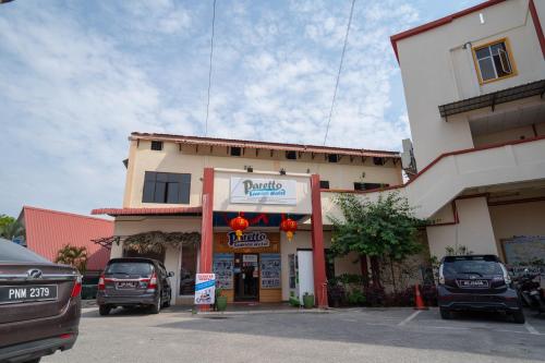 a building with cars parked in a parking lot at Paretto Seaview Hotel in Pantai Cenang