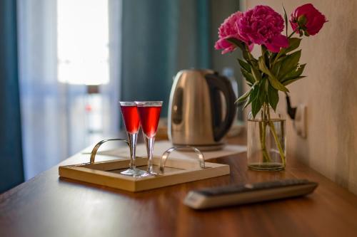 a table with two glasses and a vase of flowers at Pod Wzgórzem Bed & Breakfast in Frombork