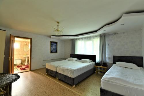 una camera da letto con due letti e un lampadario di Jamilya's B&B Guest House a Karakol