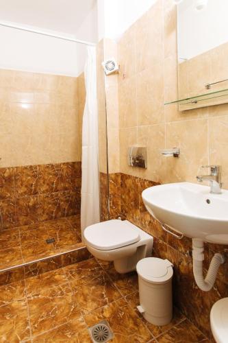 a bathroom with a sink and a toilet and a shower at Nikos Hotel in Karterados