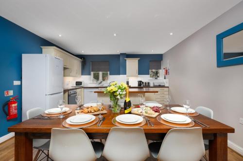 uma sala de jantar com uma mesa de madeira e cadeiras brancas em Hassop Cottage - Darwin Lake Holiday Village em Matlock