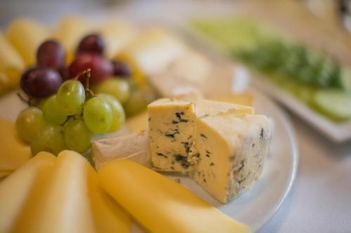 a plate of cheese and fruit on a table at Pod Wzgórzem Bed & Breakfast in Frombork