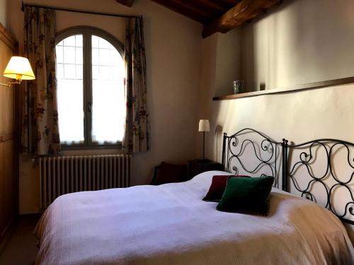 a bedroom with a large white bed with a window at Il Pezzatino in Rufina