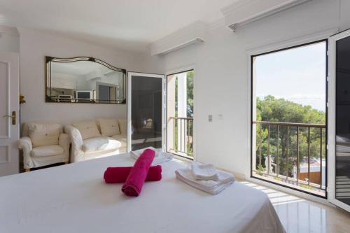a white bedroom with a large bed and large windows at Villa Ocean View in Portals Nous