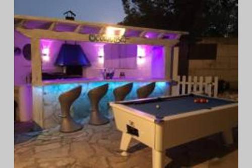 a pool table in front of a bar with purple lights at Villa Ocean View in Portals Nous