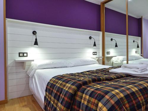 una camera con un grande letto e una parete viola di Pilar3 By Vigovacaciones a Vigo