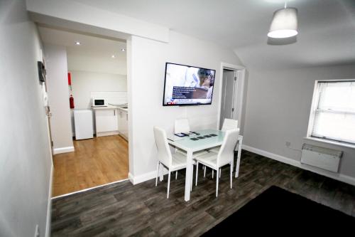 a dining room with a table and white chairs at No 5 New Inn Apartments in Newark upon Trent