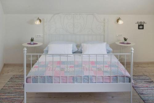 a bedroom with a white bed with two tables at Vila Eli in Brela