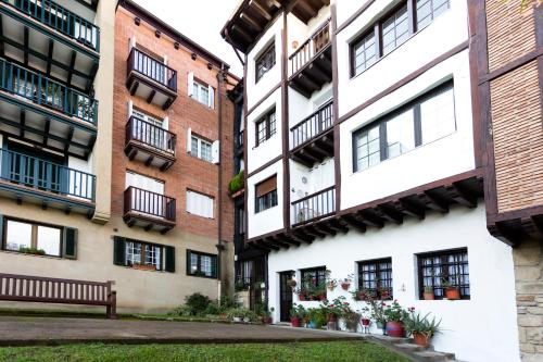 a row of apartment buildings with balconies and a bench at Olerki by Smiling Rentals in Hondarribia