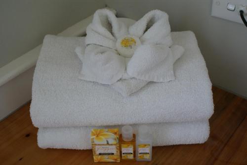 een stapel handdoeken met een bloem erop bij Warkworth Lodge in Warkworth