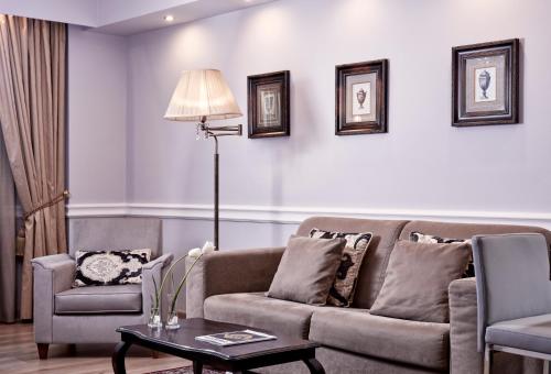 ein Wohnzimmer mit Couch und Tisch in der Unterkunft Ava Hotel and Suites in Athen