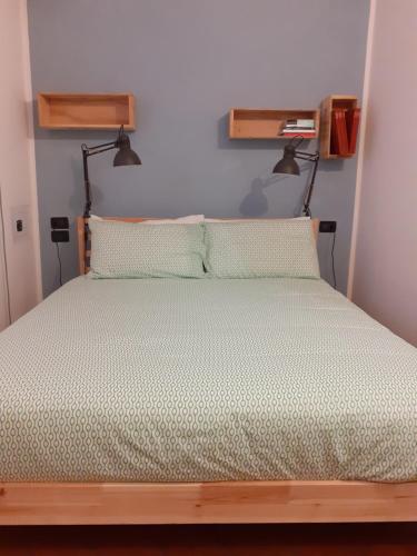 a bedroom with a wooden bed with two lights on it at La casa sulla vecchia riva in Ferrara