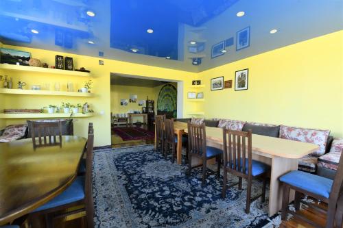 a dining room with a table and chairs and a couch at Jamilya B&B Guest House in Karakol