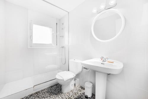 Un baño con lavabo, inodoro y espejo. en Apartaments Riu D'Incles, en Incles