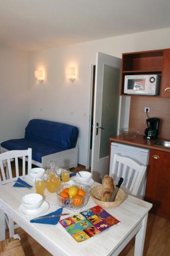 a kitchen with a white table with food on it at Appartement SC4p in Le Verdon-sur-Mer