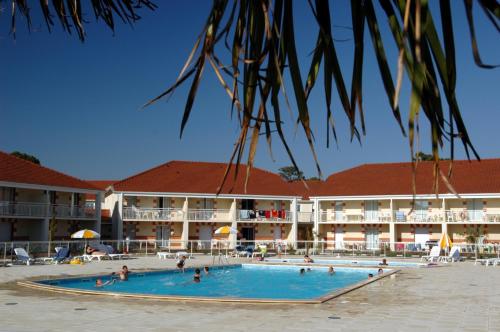a swimming pool in front of a hotel at Appartement SC4p in Le Verdon-sur-Mer