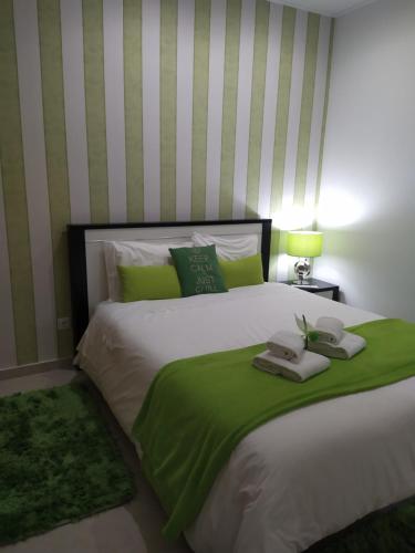 ナザレにあるCasa da Liberdade em Nazaréのベッドルーム1室(大型ベッド1台、緑の毛布付)