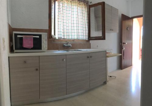 a kitchen with a sink and a microwave at Green Corner Villas in Gouvia