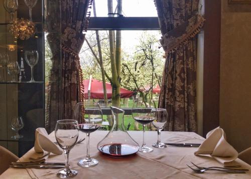 a table with wine glasses on a table with a window at Amazona Hotel in Pristina
