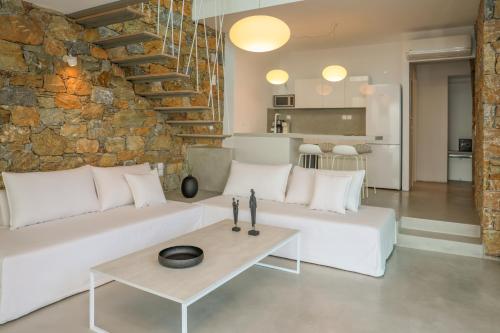 a living room with a white couch and a table at Thalasses Villas Skiathos in Skiathos Town