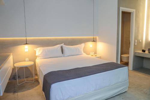 a bedroom with a large white bed in a room at Thalasses Villas Skiathos in Skiathos Town