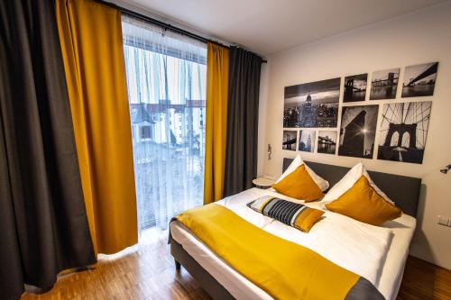 a bedroom with a bed with yellow curtains and a large window at Ruterra Apartment with Garage in Prague