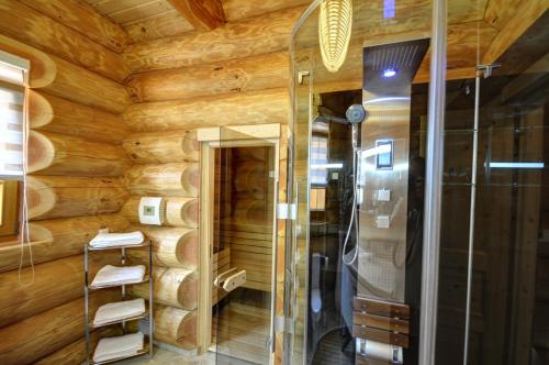 ein Badezimmer mit Holzwänden und einer Dusche in der Unterkunft Luxus-Ferienhaus Blockhaus Chalet Nr 2 Toplage am Feldberg mit Sauna, Outdoor-Hottub, Kamin auf 1300m üM in Feldberg