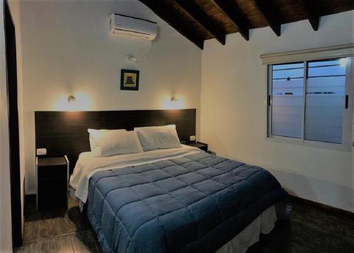 Un dormitorio con una cama grande y una ventana en Hostería Boutique El Puente Adults Only en Merlo