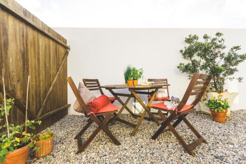 a patio with a table and chairs and potted plants at SoulSurfcamp Portugal in Peniche