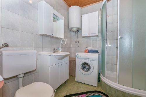 a bathroom with a washing machine and a washer at Apartment Josip in Omiš