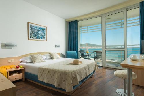 a hotel room with a bed and a large window at Effect Grand Victoria Hotel - Ultra All Inclusive in Sunny Beach
