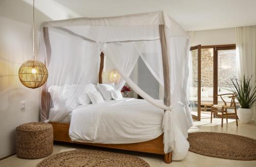 a bedroom with a canopy bed with white sheets and pillows at Villa Praia - La Villa Group in Jericoacoara