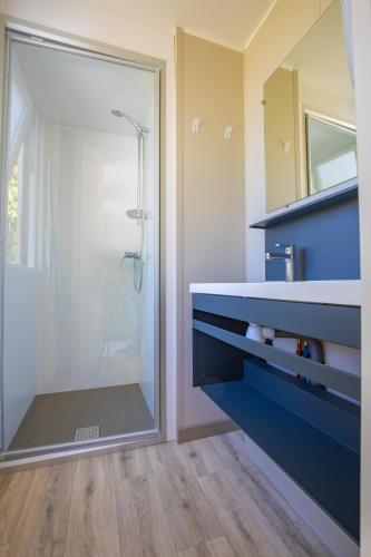 une salle de bain avec une douche avec une porte vitrée dans l'établissement Camping Taxo Les Pins - Maeva, à Argelès-sur-Mer