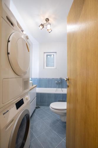 a bathroom with a washing machine and a toilet at Luxury apartman SKY with sea view and whirlpool in Makarska