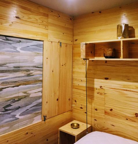 a room with wooden walls and a bed and a window at Arrábida House in Porto