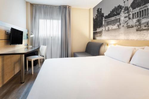 a hotel room with a bed and a desk at B&B HOTEL Madrid Aeropuerto T1 T2 T3 in Madrid