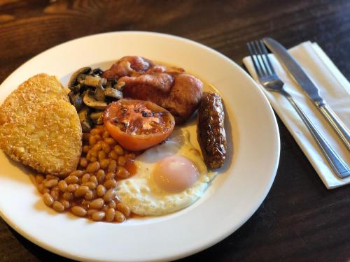 um prato branco de alimentos com ovos, feijão e cogumelos em Brentwood Inn by Greene King Inns em Rotherham