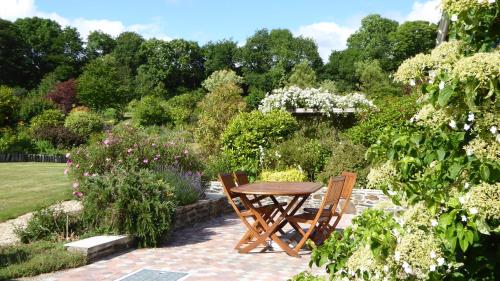 - une table et des chaises en bois dans le jardin dans l'établissement Kerlogan, à Saint-Thois