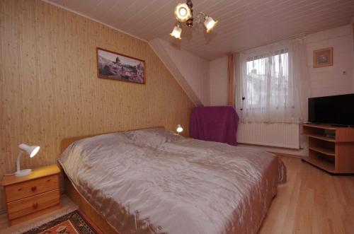 a bedroom with a bed and a flat screen tv at Fortuna Apartman in Gyula