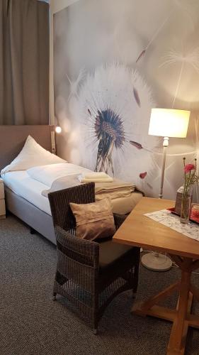 a hotel room with a bed and a table and a chair at Landhaus Heidekrug in Hildesheim