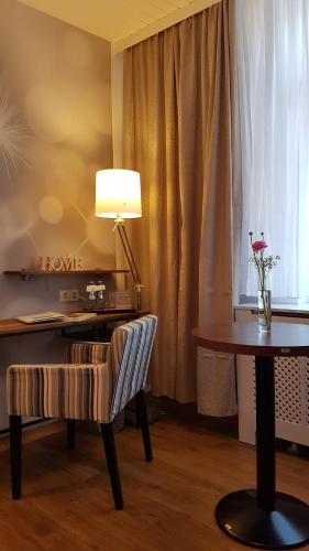 a room with a desk and a table with a lamp at Landhaus Heidekrug in Hildesheim